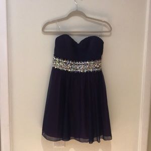 A short purple strapless dress with rhinestones.